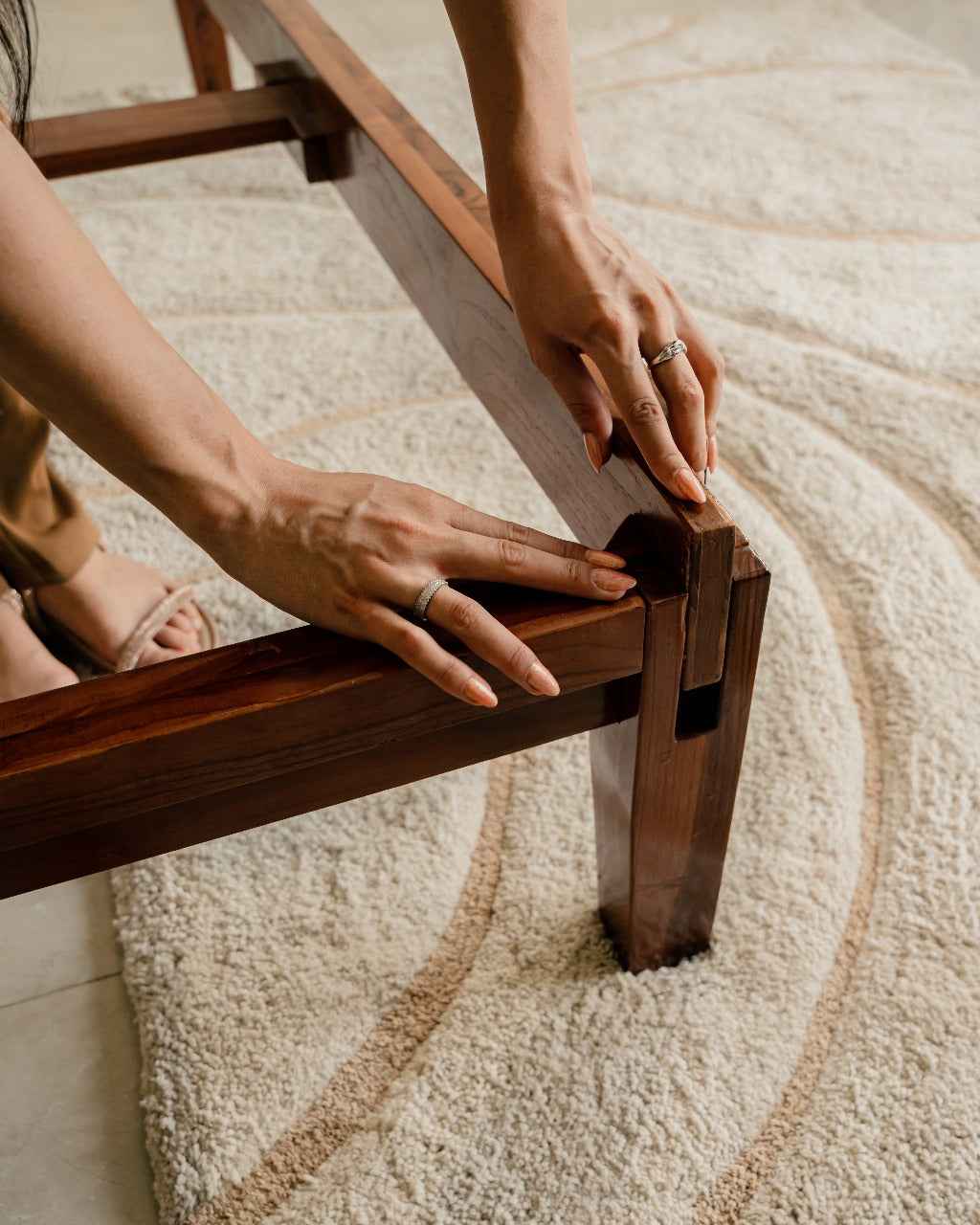 Person adjusting a wooden bed