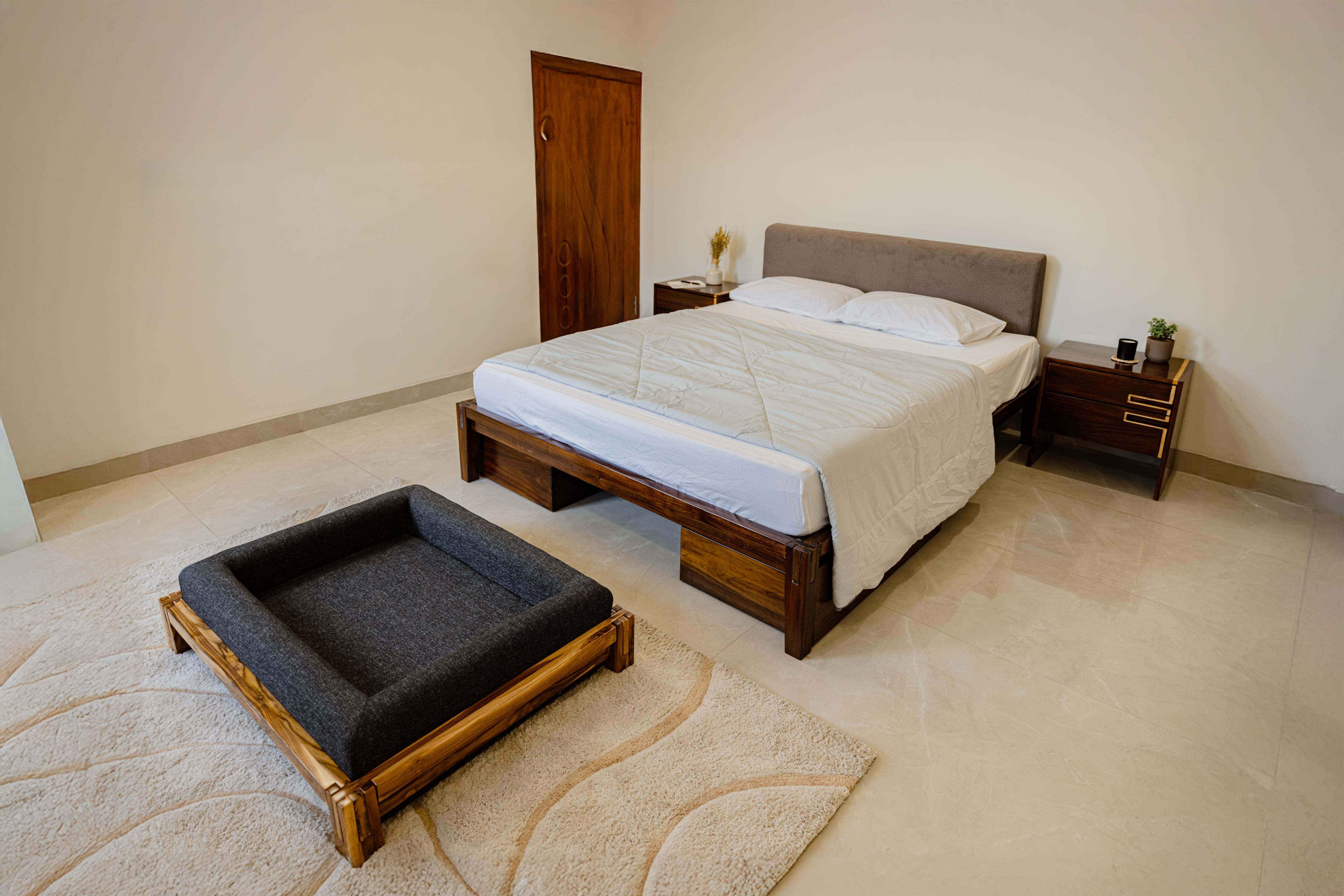 Bedroom with a bed and a dog bed on the floor.